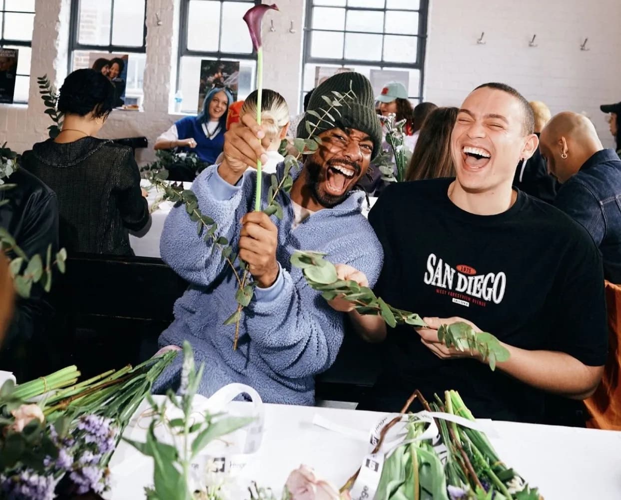 Deux participants rient pendant un atelier de composition florale